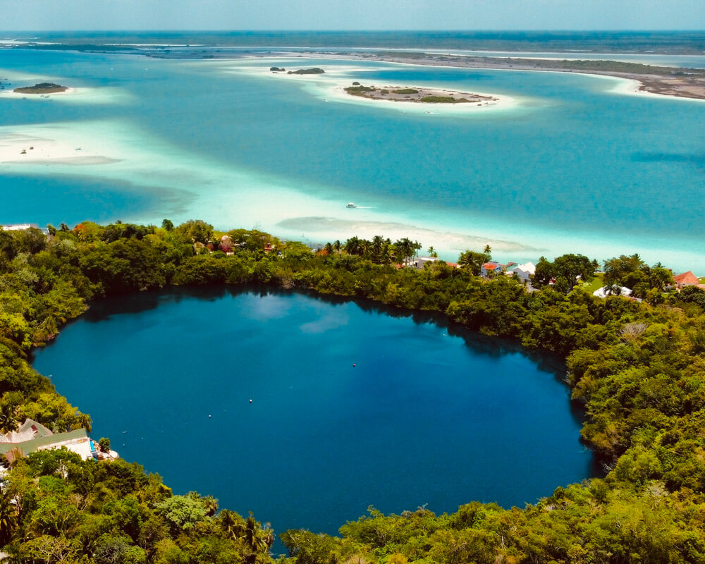 Hoyo Azul Cenote: A blue lagoon surrounded by green trees and blue ocean