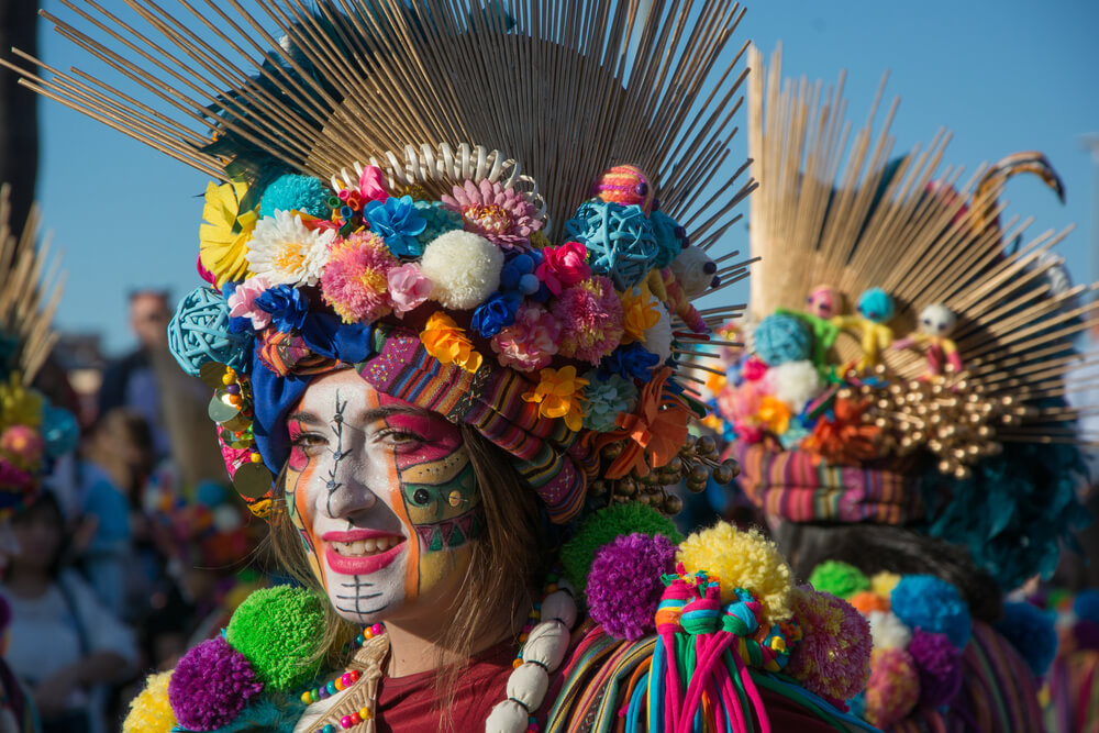 Karneval in Spanien: Frau mit bemaltem Gesicht und buntem Kostüm