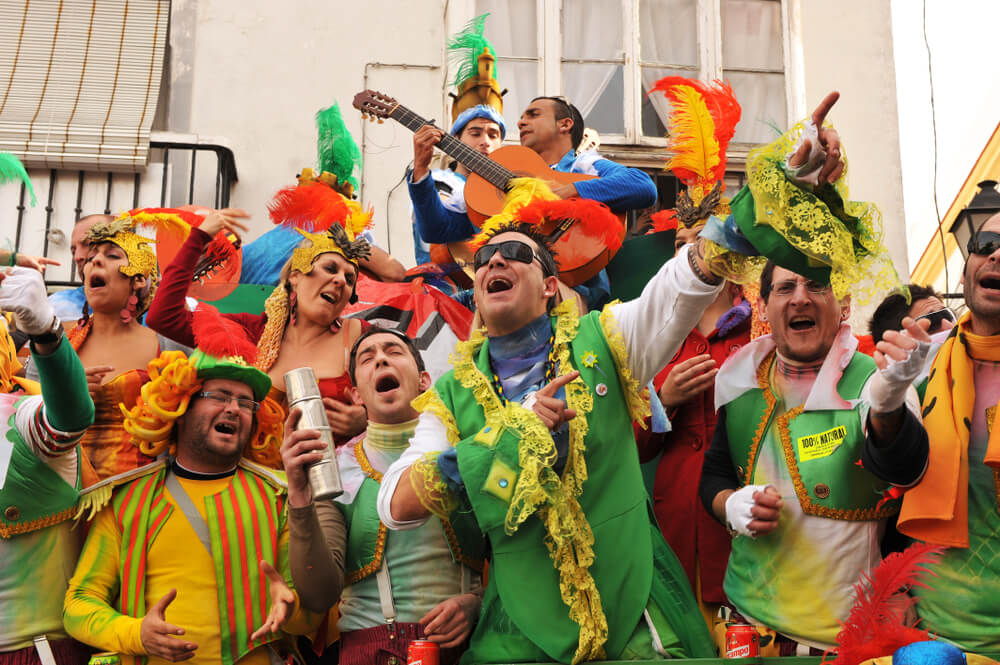 Karneval in Spanien: verkleidete Menschen singen in Cádiz auf einem Karnevalswagen. 