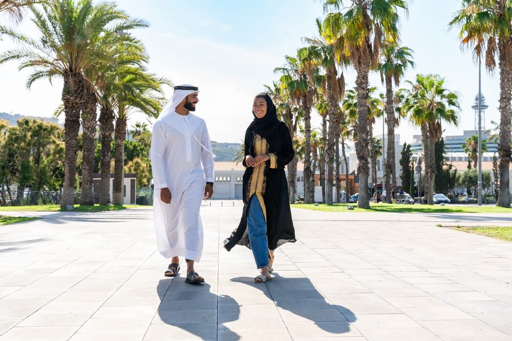Traditionelle Kleidung in Dubai: Mann mit Kandura und Frau mit Abaya.
