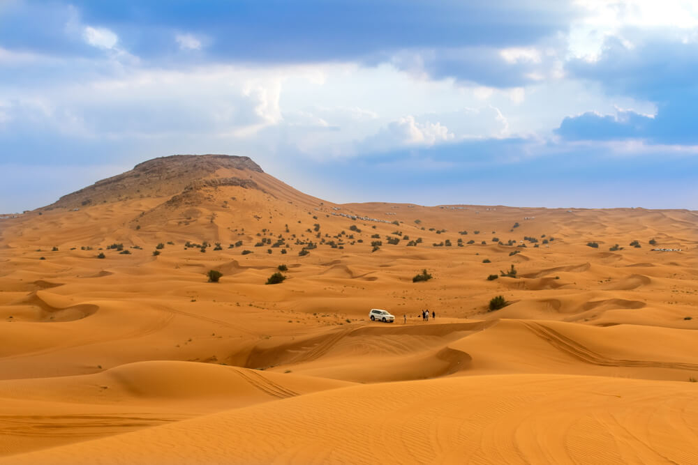 Jeep mit Touristen in der Wüste von Dubai.