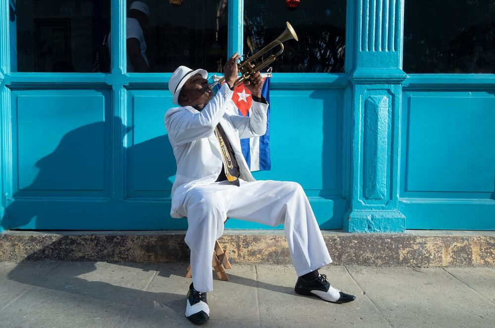 Kuba Kultur: Kubaner spielt Trompete an einer Türschwelle