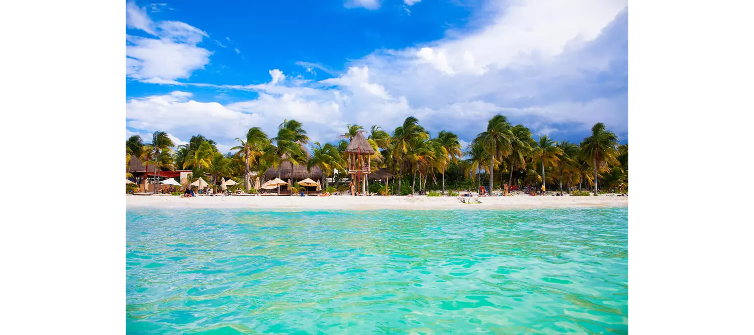 Places to go in Cancún: The white sandy shoreline of Isla Mujeres from a distance