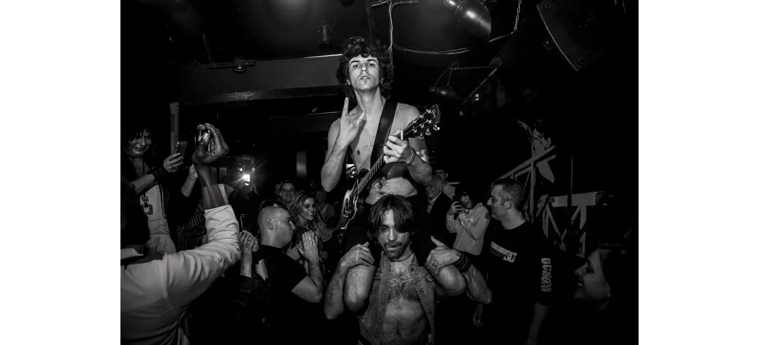 Live music in Madrid: Black and white photo of men partying at a rock concert