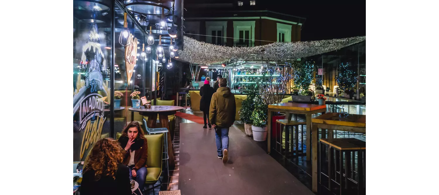 Live music in Madrid: People sitting at a bar in Chueca at night