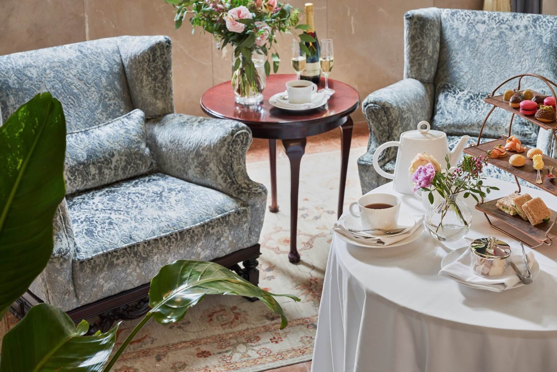 Afternoon Tea: A white table laid for afternoon tea and two blue armchairs