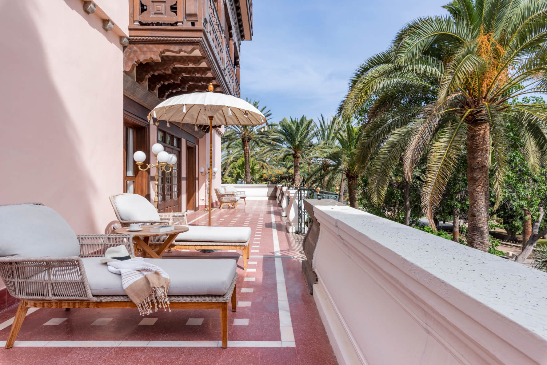 Balcony: A red marble floor and pink-walled balcony with sun loungers