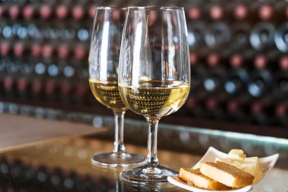 Wine tasting: Two white wine glasses with a side dish of tapas