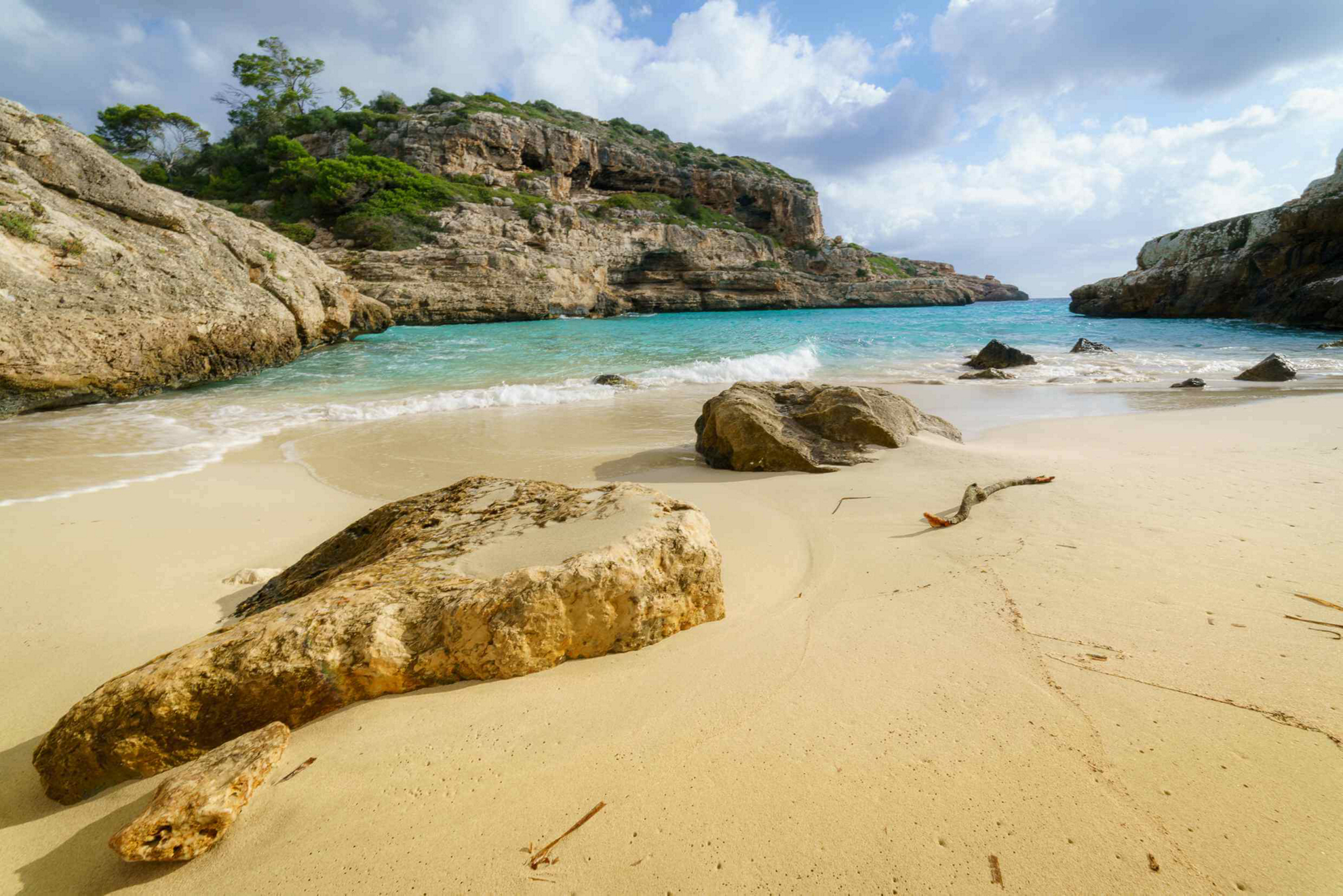 Kleine Bucht mit weißem Sand und Felsen auf Mallorca.