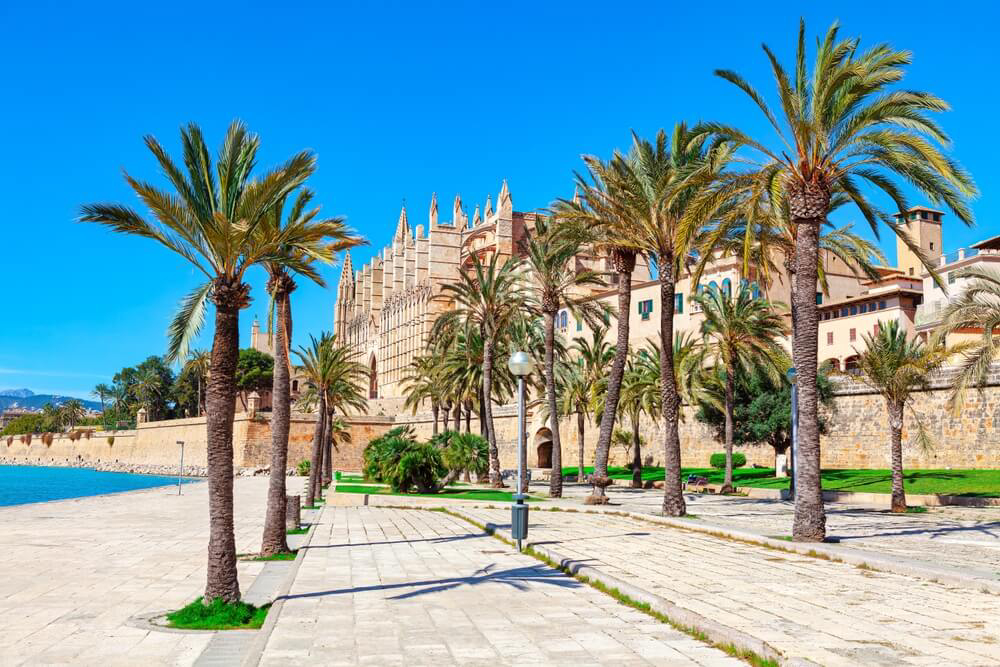 Mallorca family holidays: A golden stone-walled square with palm trees