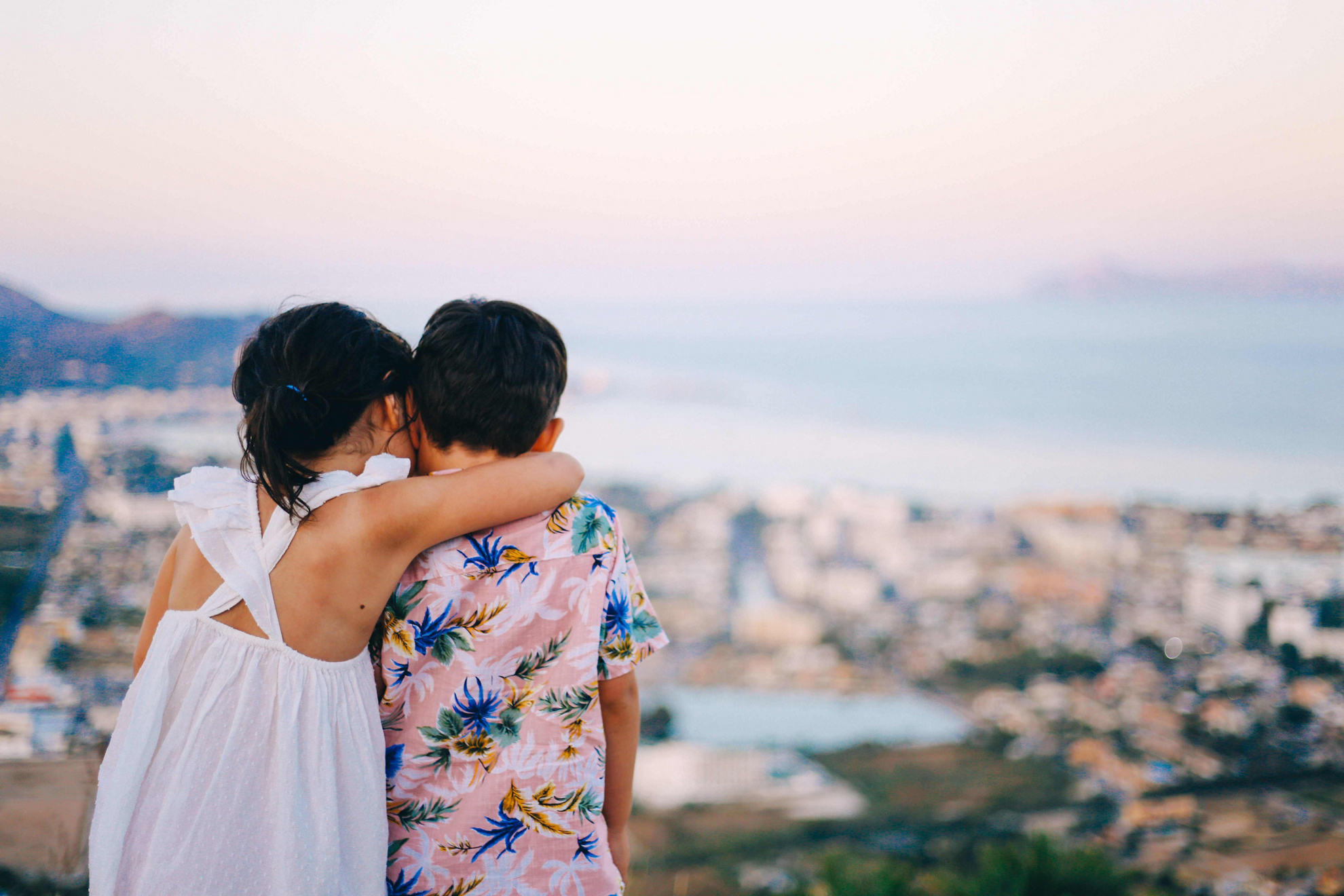 Mallorca family holidays: Two children sat on a wall overlooking the ocean