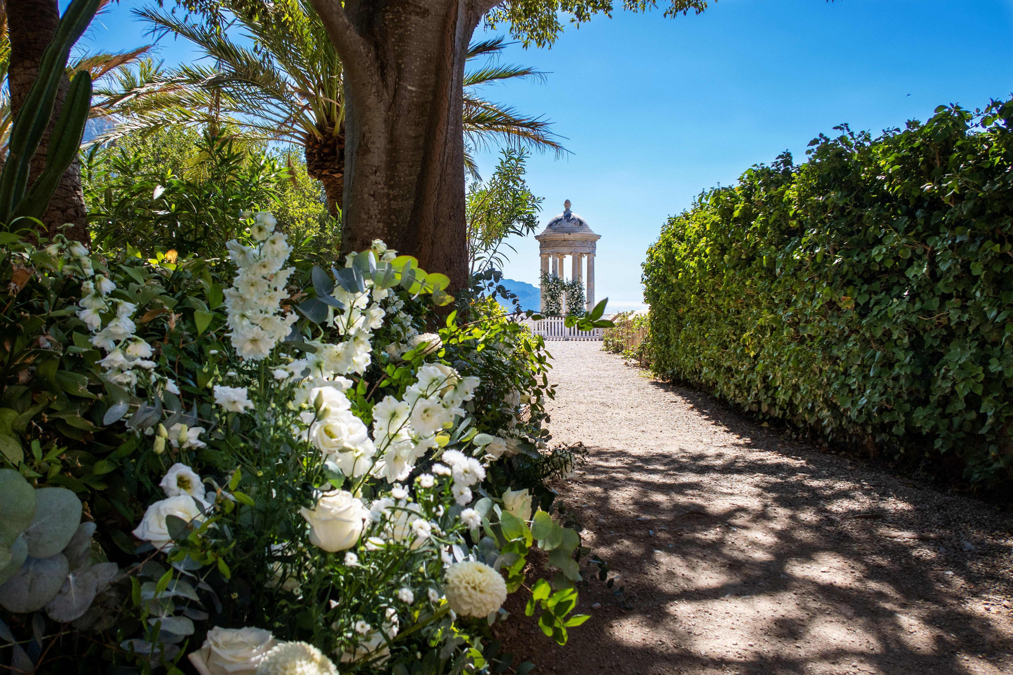 Mallorca for couples: A gravel path lined with flowers and a small domed patio at the end