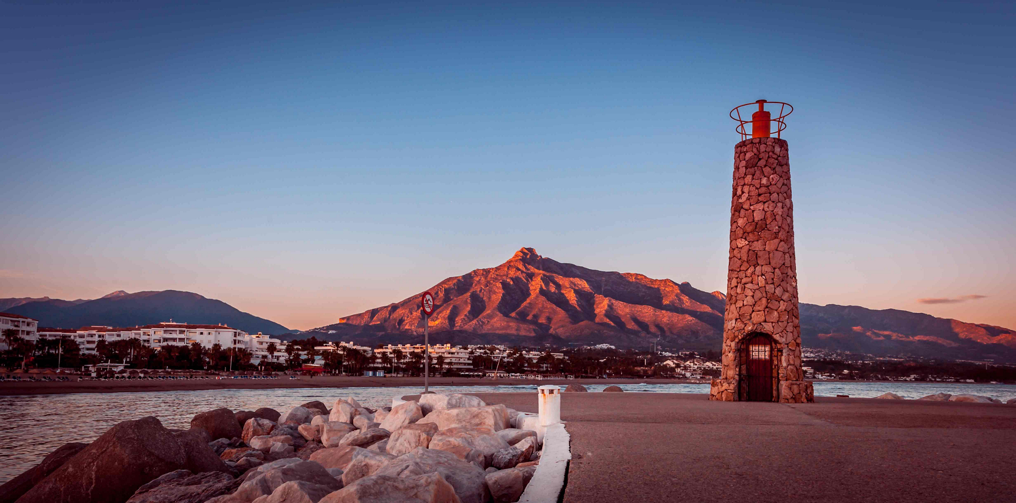 Things to do in Marbella: The beach in Marbella at sunset with a lighthouse in shot