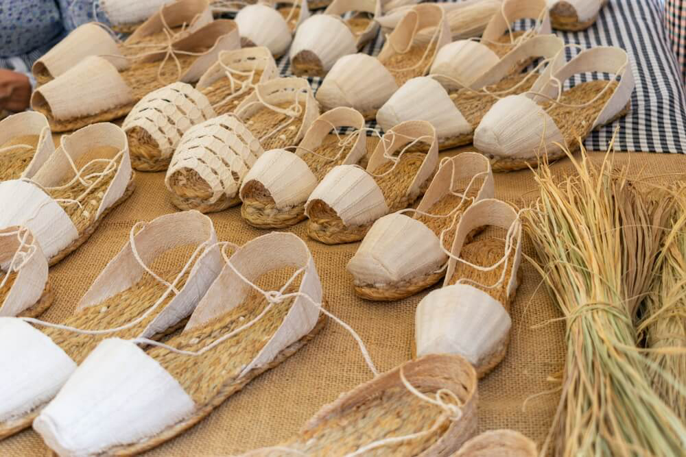 Espadrilles: A table of white espadrilles at a market