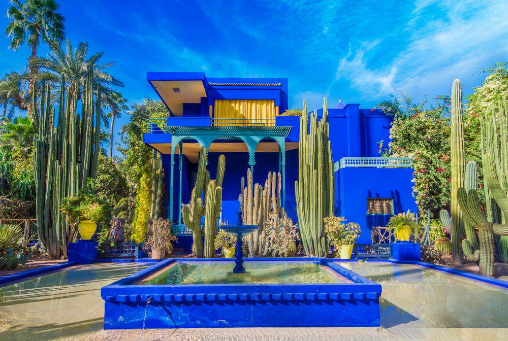 Blaues Gebäude, von Pflanzen umgeben, im Jardin Majorelle in Marrakesch.