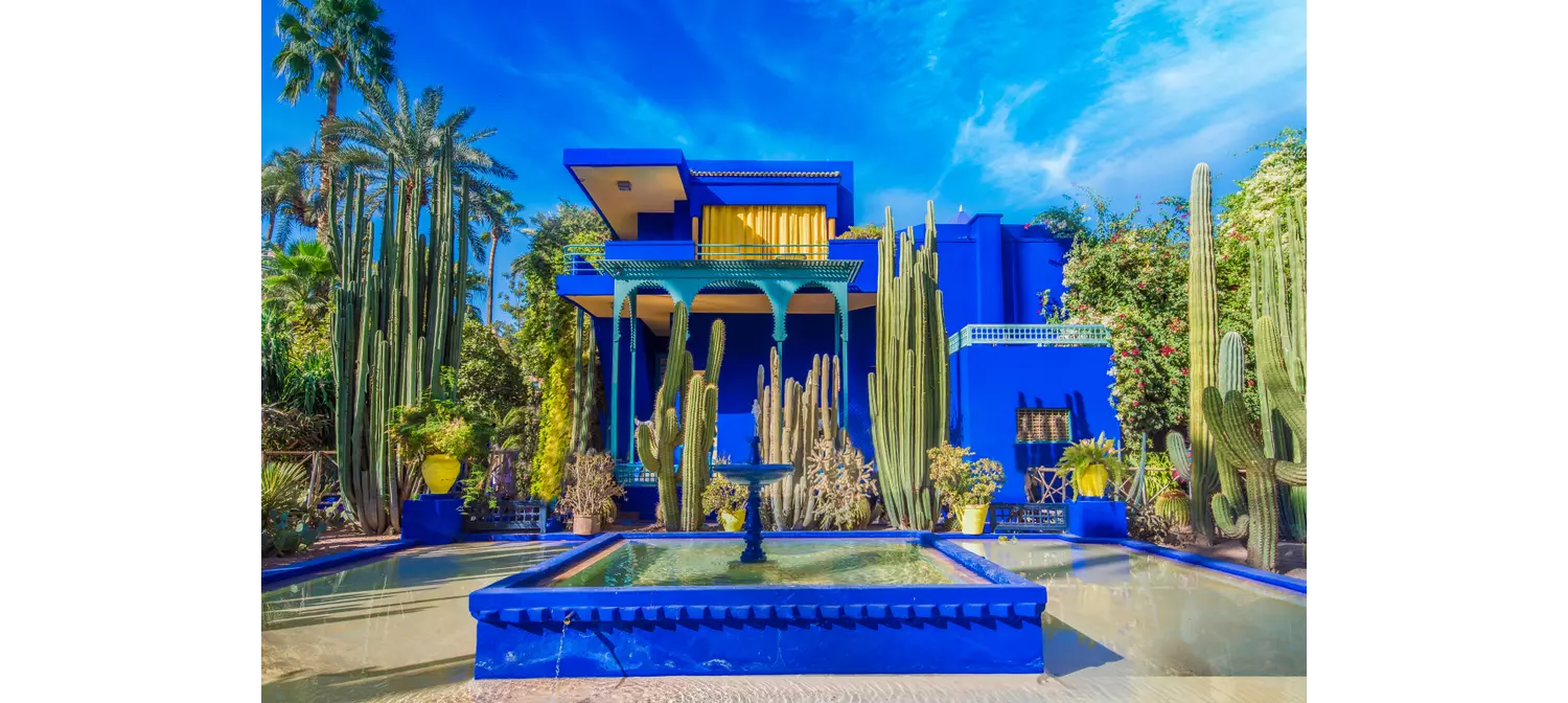 Blaues Gebäude, von Pflanzen umgeben, im Jardin Majorelle in Marrakesch.