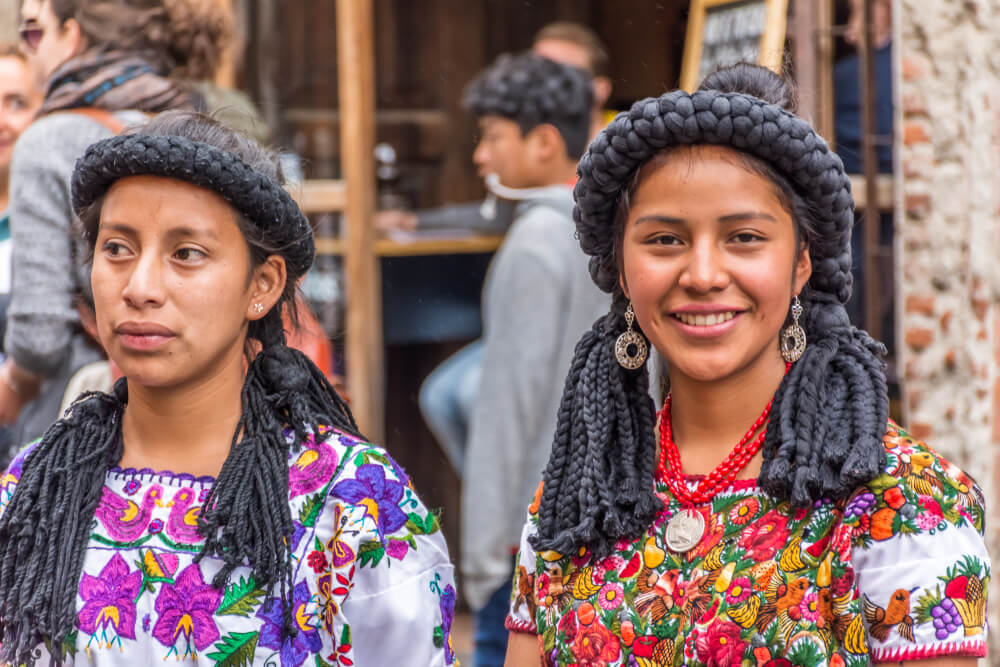 Zwei Frauen des Maya-Volkes mit traditionellen Trachten und Frisuren.