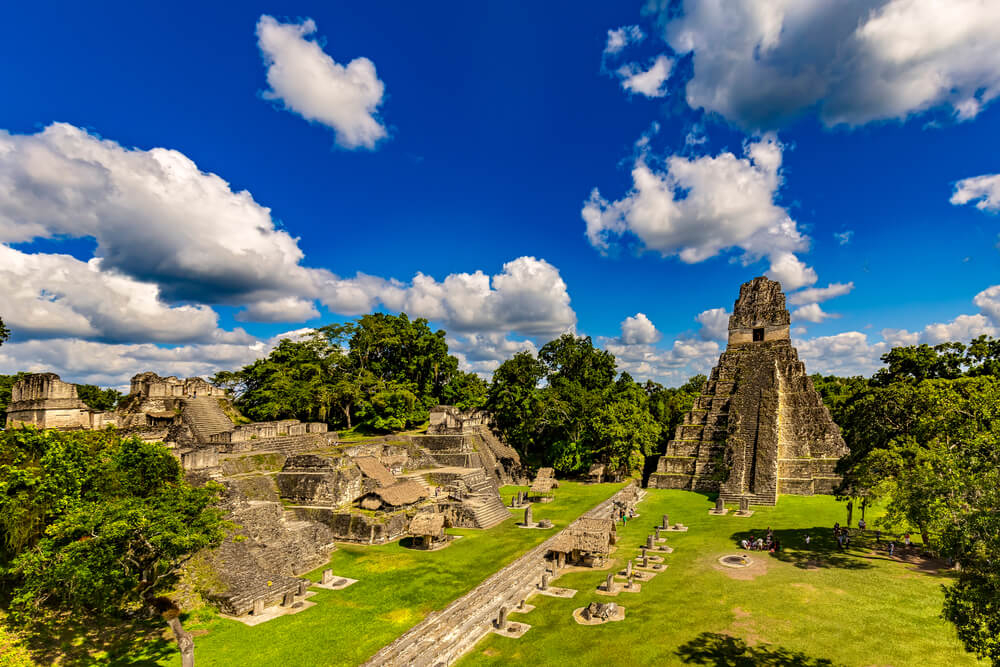 Tikal: A tall, thin stone pyramid surrounded by other buildings