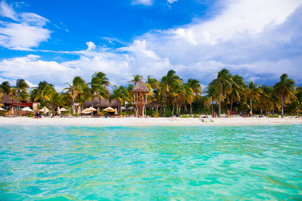 Crystal-clear waters of the sea wash up on the white sands of Playa Norte on Isla Mujeres, Mexico.