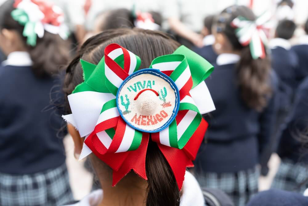 Young woman hold a Mexican flag on their backs in celebration Mexican Independence Day.