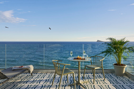 Gedeckter Tisch auf Hotelbalkon mit Blick aufs Mittelmeer.