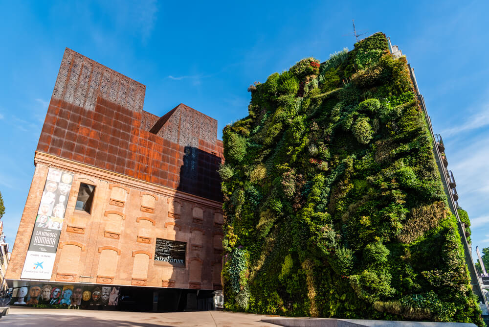 Caixaforum: Red modern building next to a green living wall