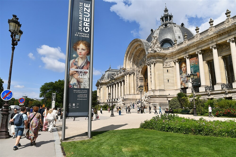 Petit Palais: A domed stone building with a garden at the front and a gallery advert 