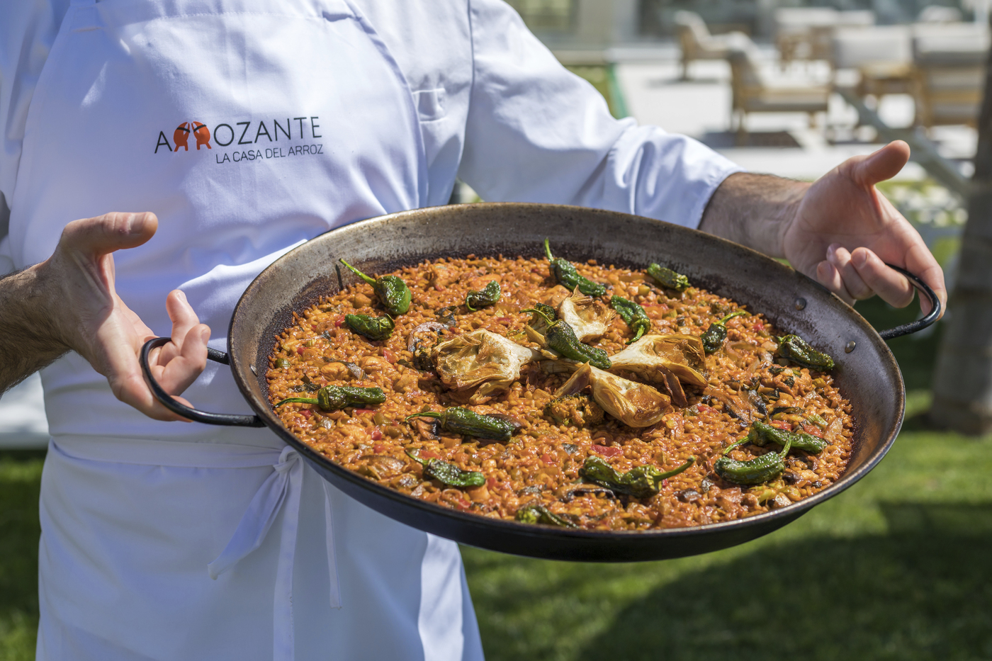 Nachhaltige Gastronomie : Koch präsentiert eine fertige Paella aus Produkten der Region.