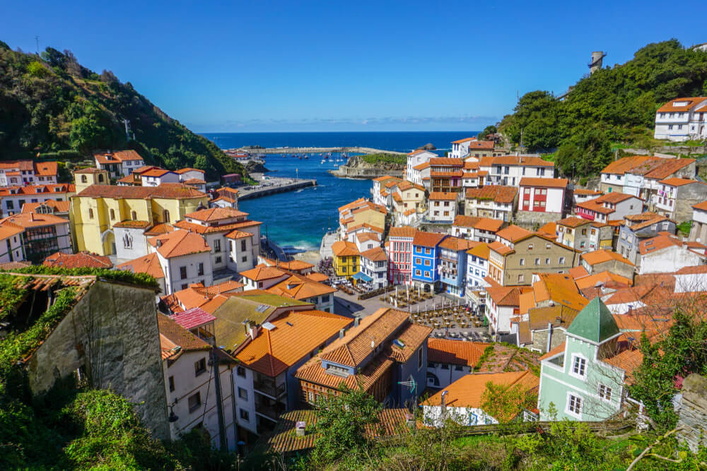 Urlaub in Asturien: kleiner Küstenort mit orangenen Dächern und natürlichem Hafen