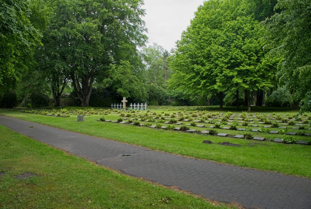 Von hohen Bäumen umgebene Gräber auf dem Ohlsdorfer Friedhof in Hamburg.