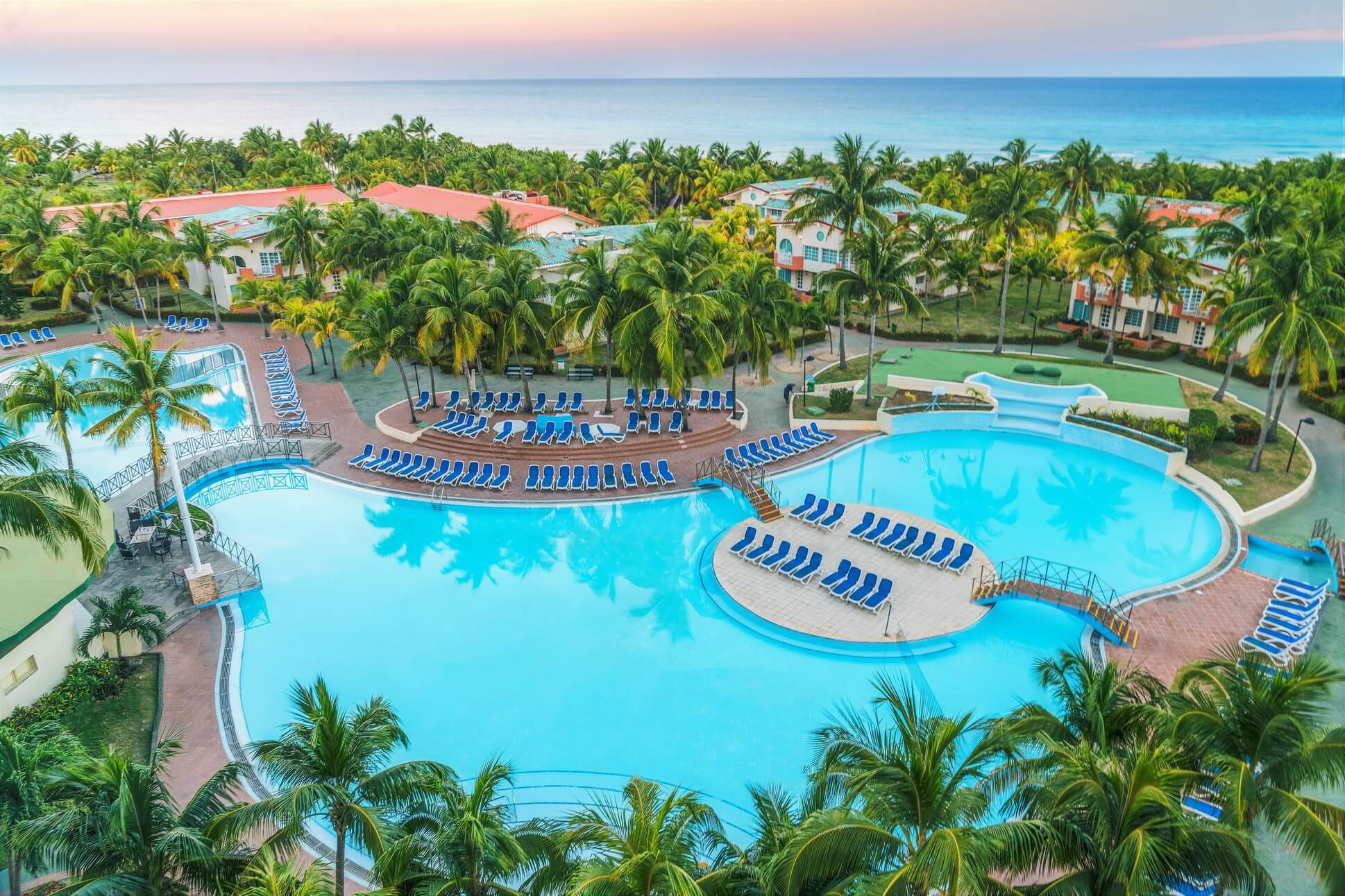 Barceló Solymar: A swimming pool surrounded by loungers and a palm tree forest