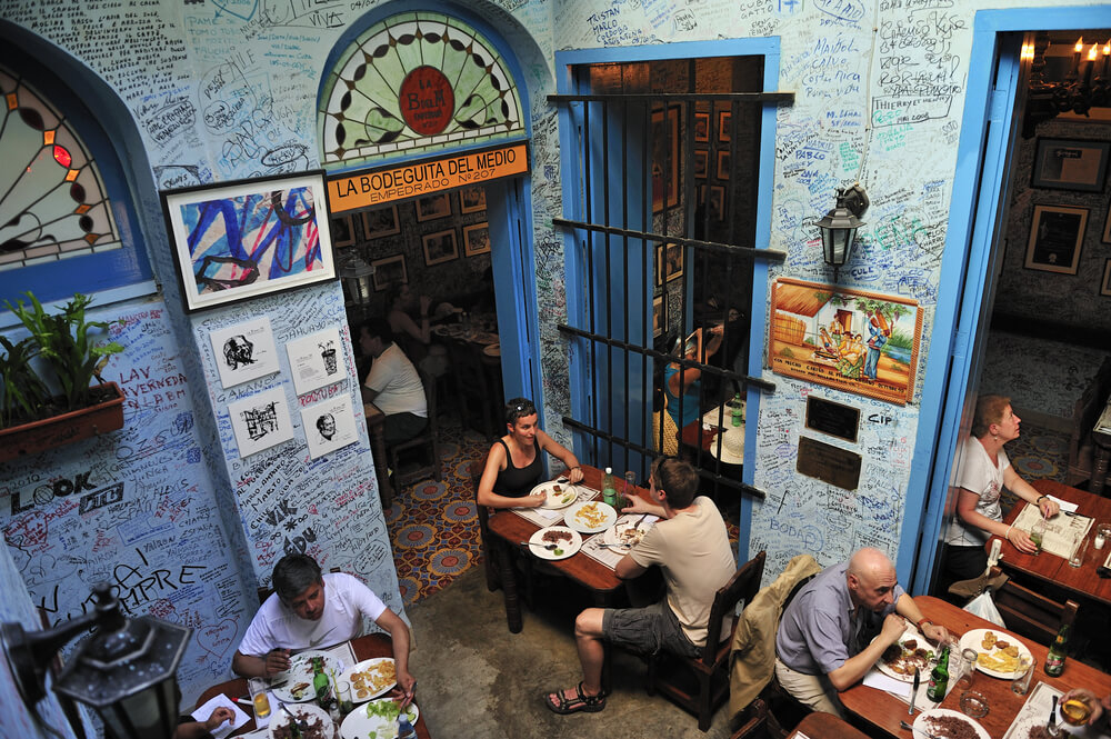 Places to visit in Cuba: The Bodeguita del Medio, blue interiors with tables of people