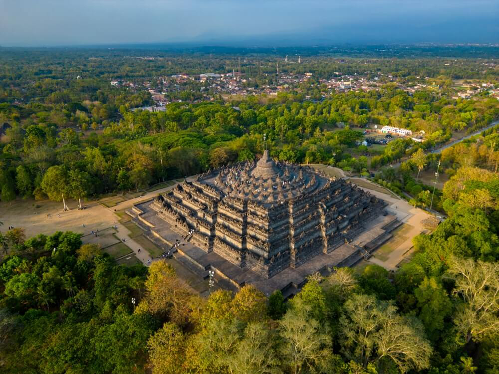 Borobudur Temple: A stone pyramid style temple surrounded by green