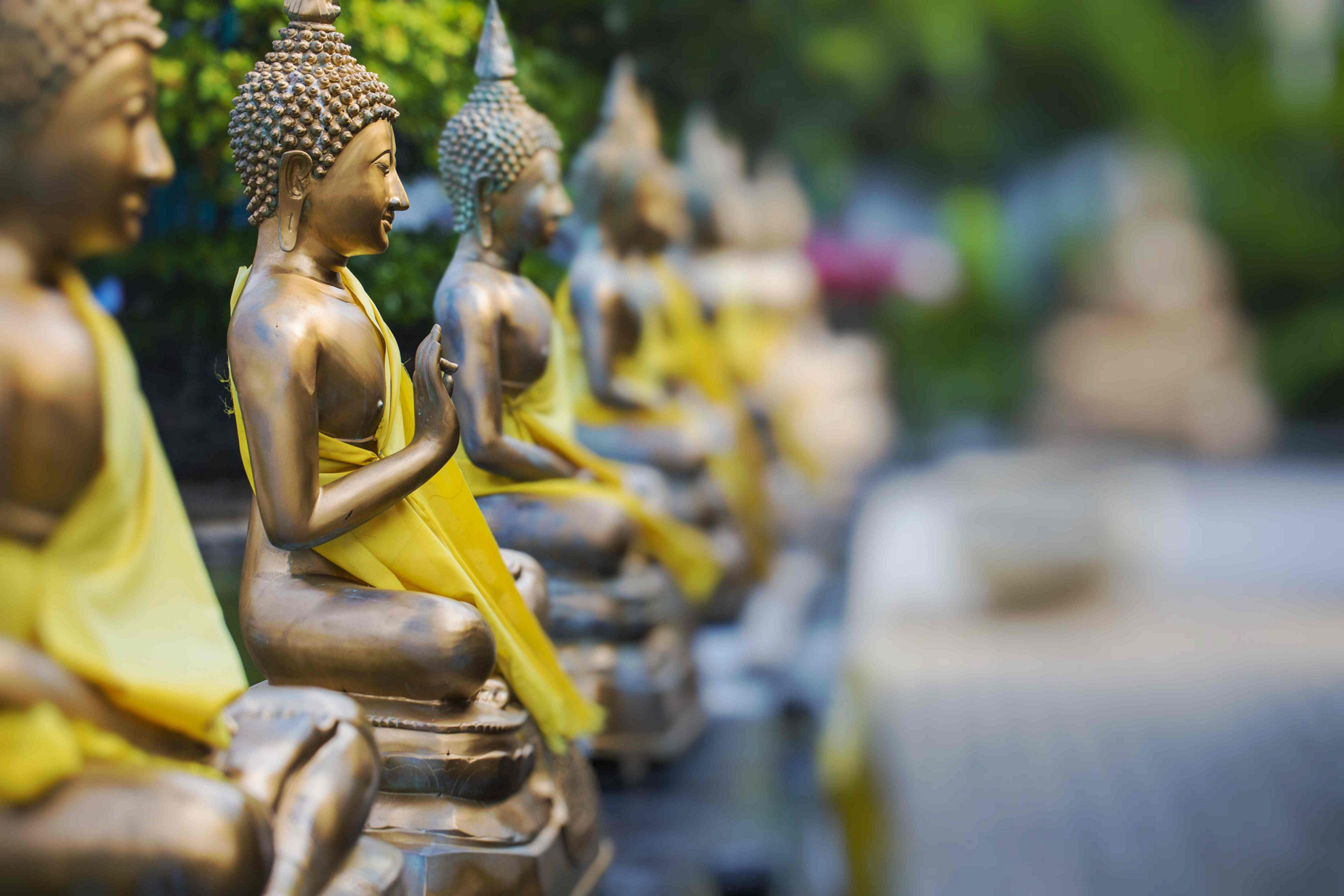 Relaxing holiday destinations: A row of bronze Buddha statues lined up outside