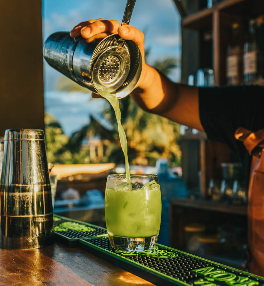 A barman prepares a cocktail for a Puerto Aventuras nightlife experience