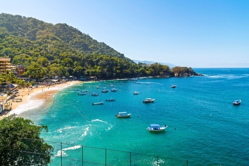 Boote vor dem tropischen Strand von Mismaloya in Puerto Vallarta, Mexiko.