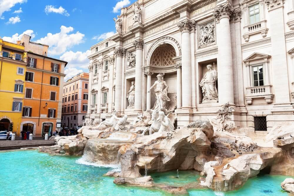 Seitliche Ansicht des Trevi-Brunnens in Rom mit Wohnhäusern im Hintergrund „Fontana di Trevi“