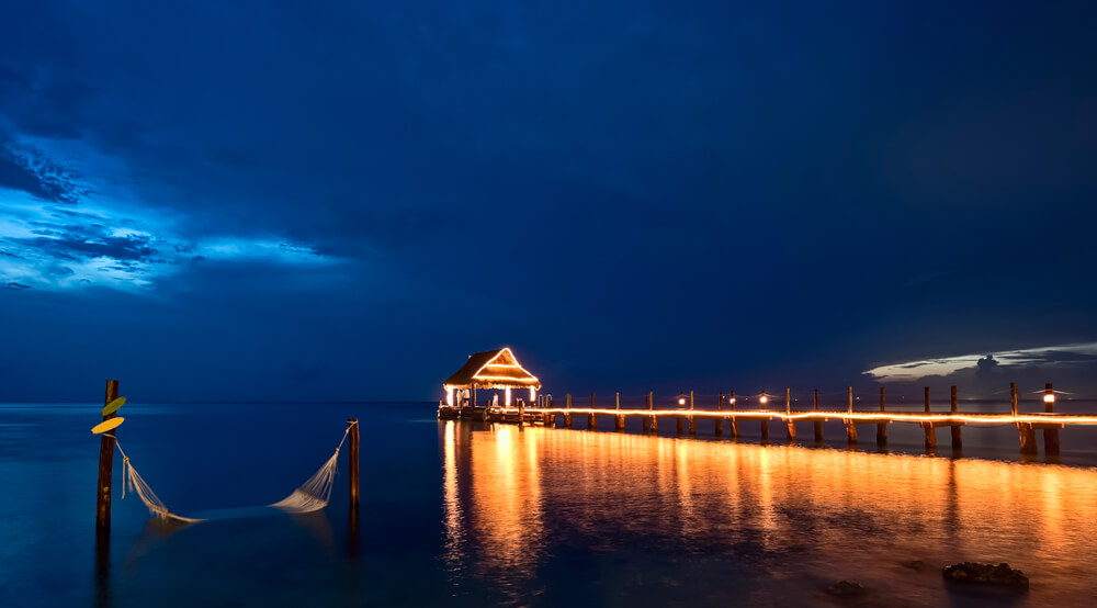 Cozumel attractions: The beach in Cozumel at night with an illuminated pier