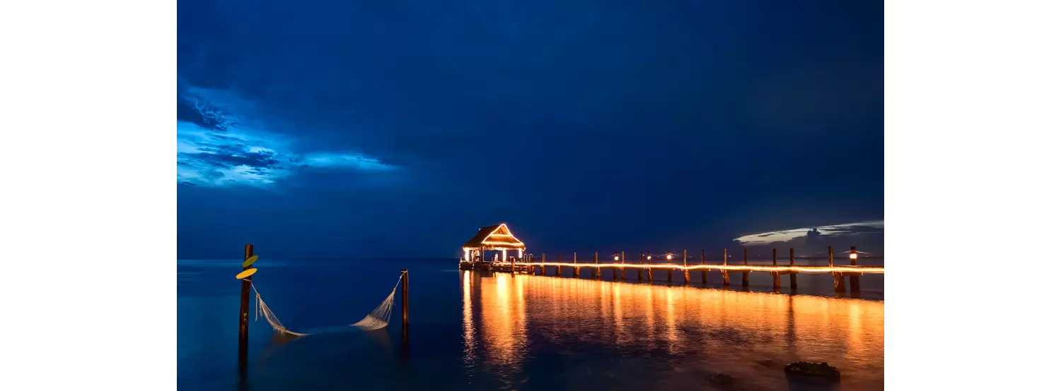 Cozumel attractions: The beach in Cozumel at night with an illuminated pier