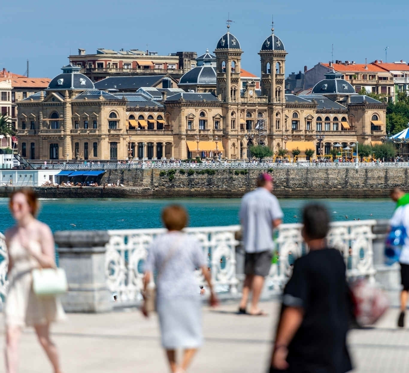 promenade of San Sebastian with city hall and strolling pedestrians in the foreground