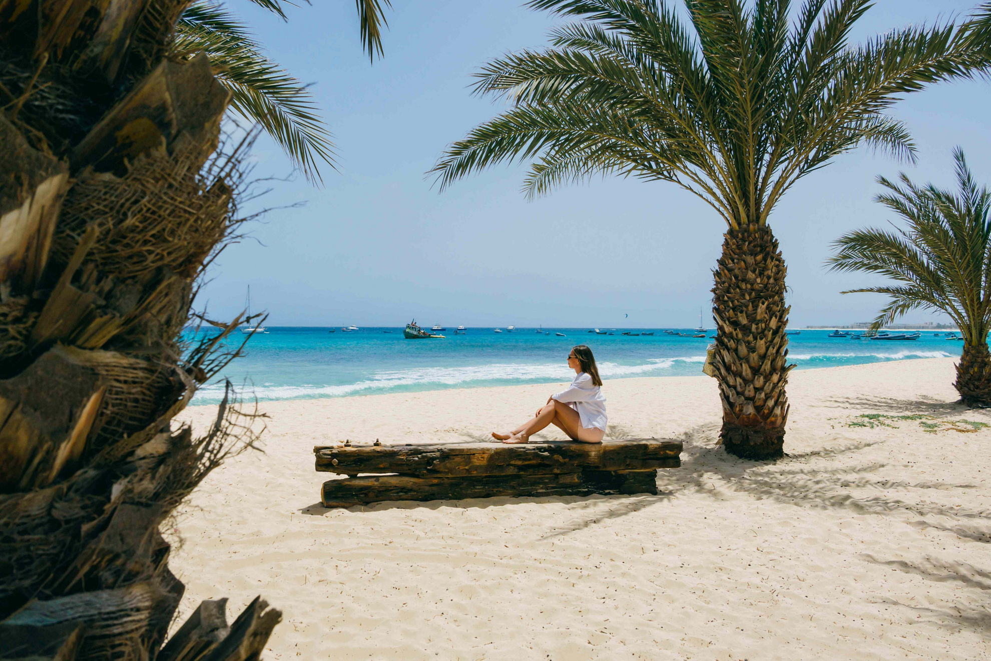Sal Island: Woman seated on a tree trunk on a white sand beach