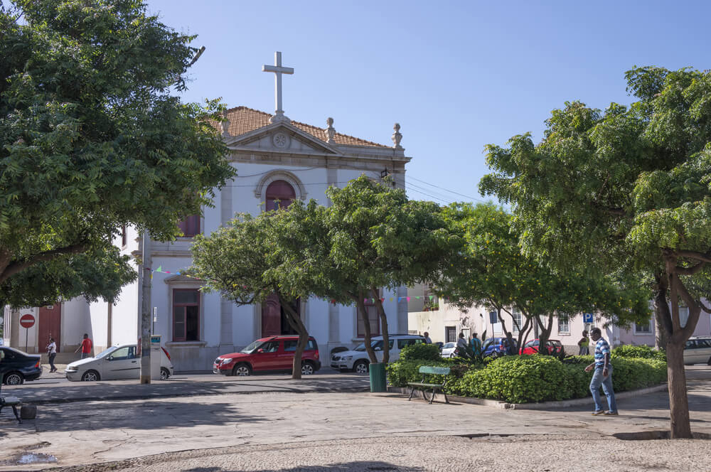 Church of Our Lady of Grace: A close-up of the white colonial church surrounded by trees