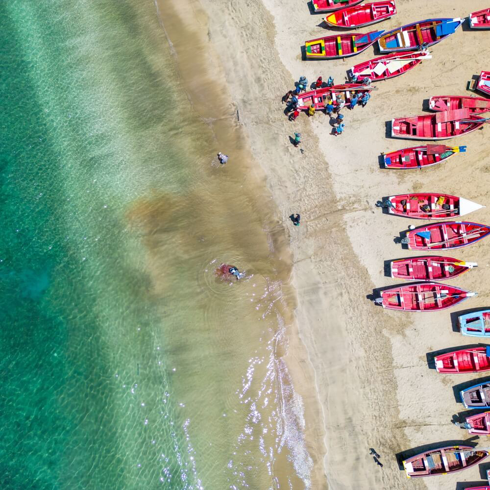 Quebra Canela Beach: Golden sand and turquoise ocean with fishing boats on the shore