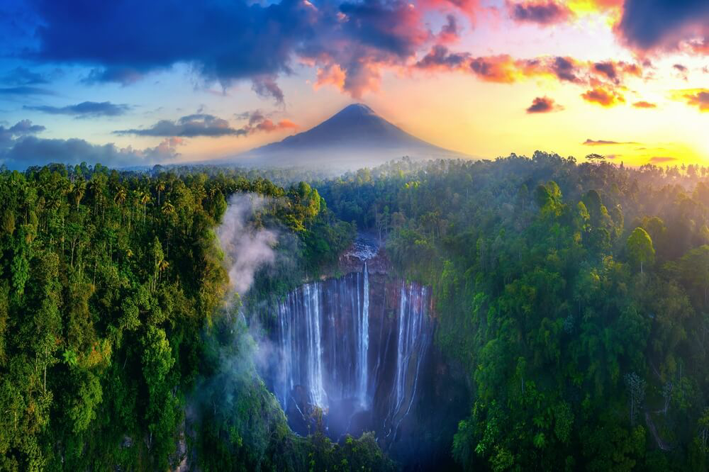 Der Tumpak Sewu-Wasserfall mit dem Vulkan Semeru im Hintergrund in Java, Indonesien.