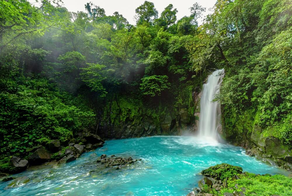 Türkisblaues Wasserbecken unter dem Wasserfall des Río Celeste in Costa Rica.