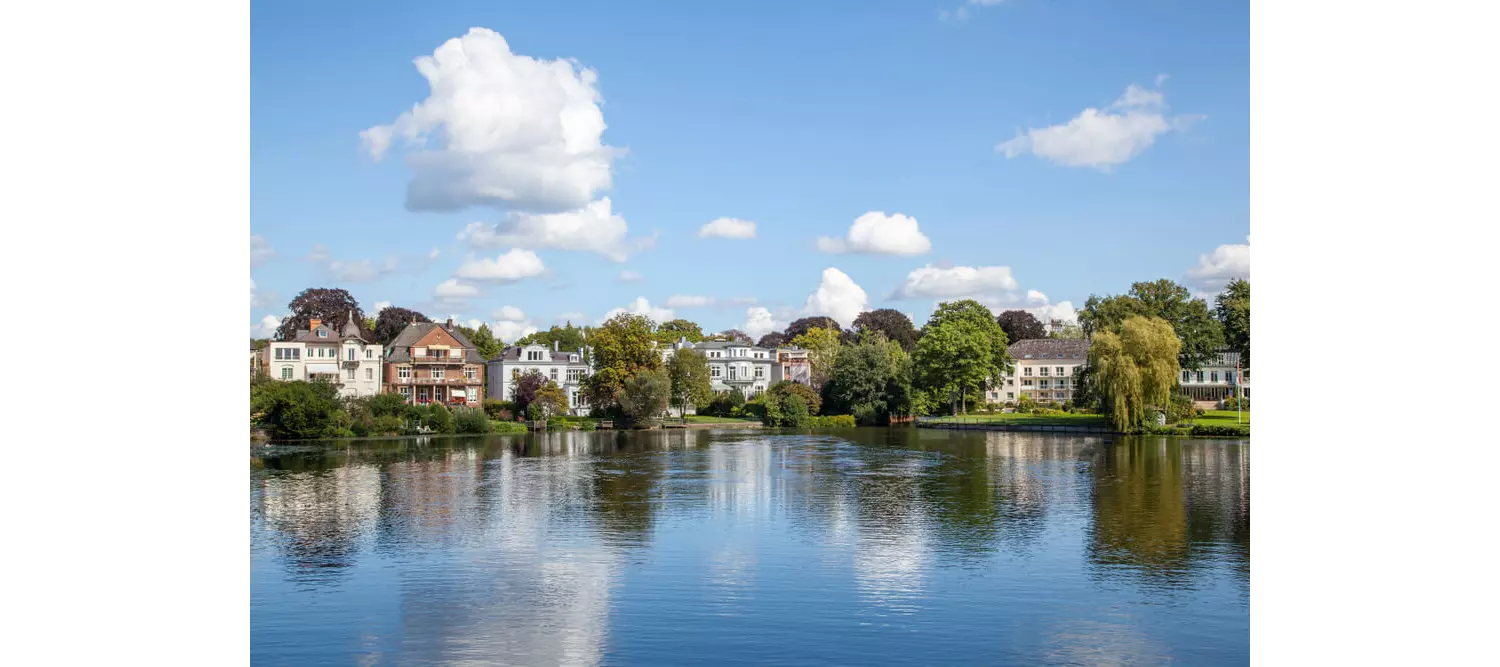 Aktivitäten in Hamburg: Bäume und Häuser am Ufer der Außenalster, ideal zum Kajakfahren.