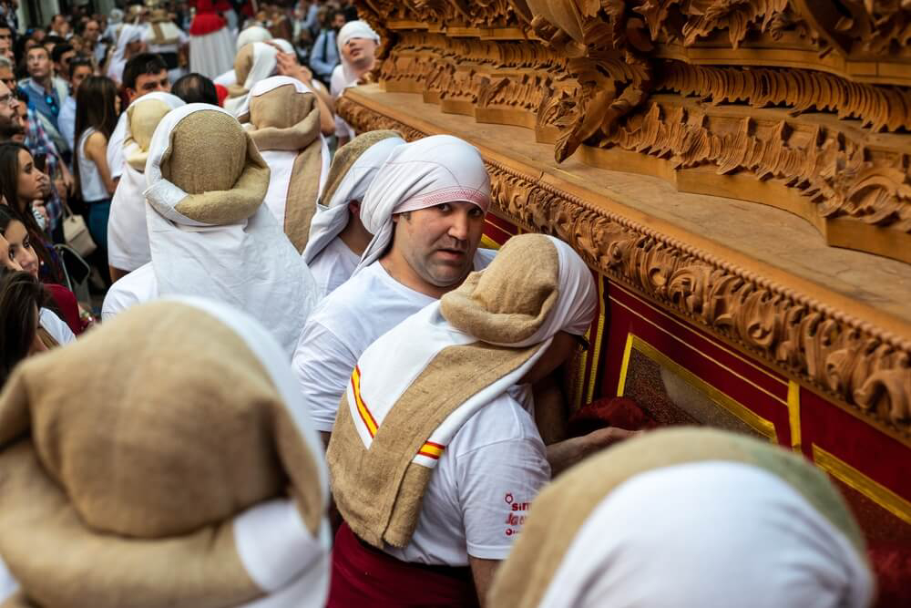 Costaleros: Men in religious attire carrying an elaborate float in Holy Week