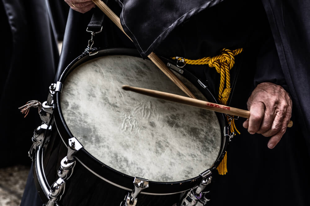 Semana Santa: Three men dressed in hooded red robes at Easter in Spain