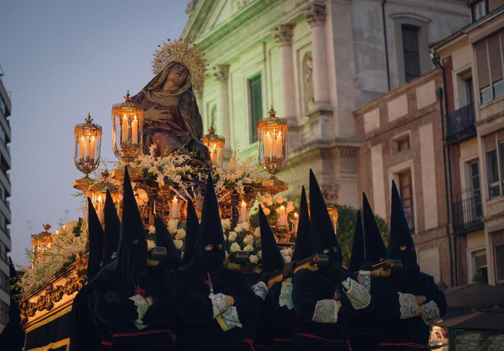 Granada: A group of black cloaked men carrying an elaborate float