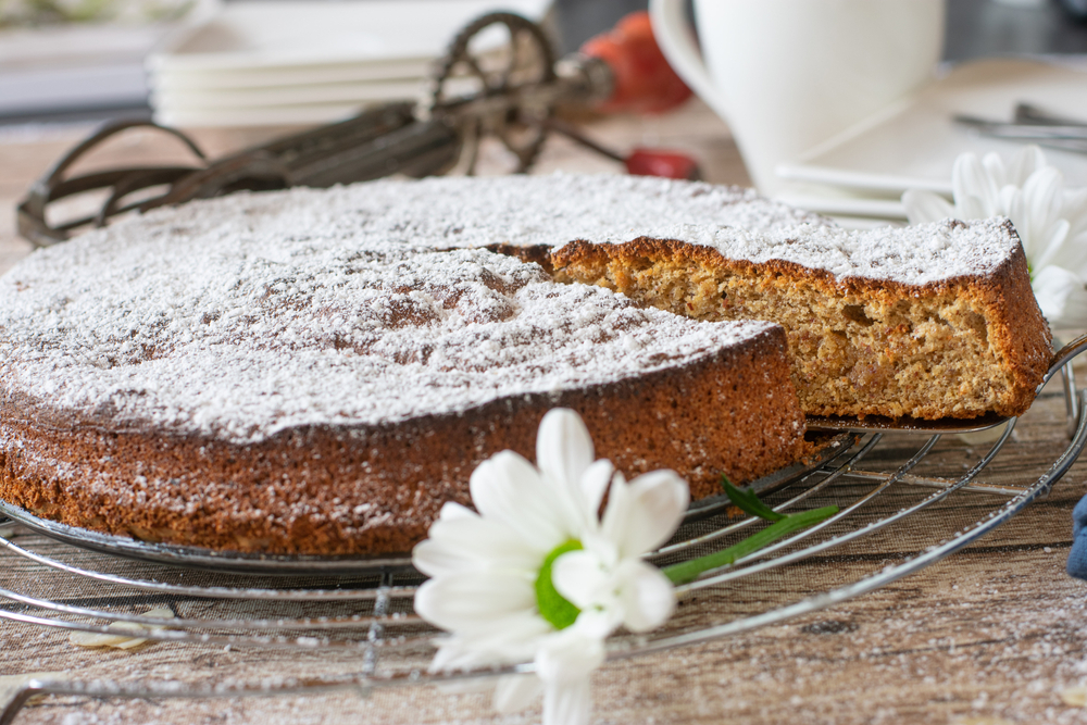 Mallorcan almonds: An almond cake dusted with sugar on a table with a white flower